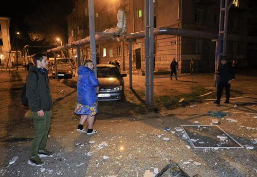 epa12008774 Locals stand outside a damaged residential building at the site of a drone attacl in Kharkiv, Ukraine, late 03 April 2025 (issued 04 April 2025), amid the ongoing Russian invasion. At least four people died and 35 other people were injured, including one child, according to the State Emergency Service.  EPA/SERGEY KOZLOV