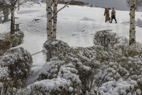 epa12020142 Women walk in a park after a snowfall in Moscow, Russia, 09 April 2025. Huge snowfall and low temperatures up to minus nine Celsius degrees hit Moscow during the week after a normal warm and snowless winter. The thickness of the snow cover in Moscow is 20 centimeters, and in the Moscow region it reaches 30 cm.  EPA/SERGEI ILNITSKY