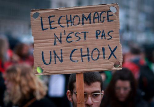 epa12051211 A protester holds a banner reading 'unemployment is not a choice' during a protest against the social reforms of the government in Brussels, Belgium, 24 April 2025. Belgium's new federal government, led by Prime Minister Bart De Wever since February 2025, has implemented significant reforms to social rights, labor laws, and welfare policies,...