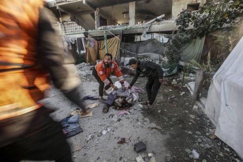epa12054656 GRAPHIC CONTENT - Palestinians inspect the body of a man following an Israeli airstrike, at Al Farabi school in Gaza City, northern Gaza Strip, 25 April 2025. According to the Palestinian Ministry of Health in Gaza, at least three Palestinians were killed and 10 others wounded in Israeli airstrikes.  EPA/MOHAMMED SABER -- ATTENTION EDITORS:...