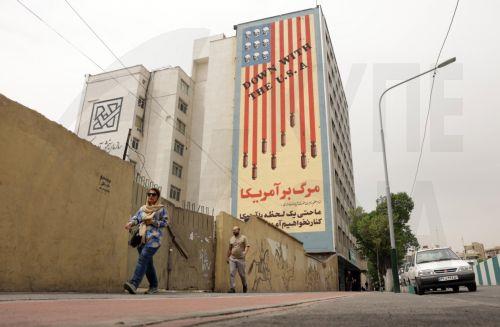 epa12055725 Iranians walk near an anti-US mural in a street in Tehran, Iran, 26 April 2025. Iran and the US will hold a third round of nuclear talks on 26 April in the Omani capital of Muscat.  EPA/ABEDIN TAHERKENAREH