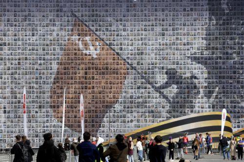 epa12069328 People walk on the Dvortsovaya (Palace) Square decorated with a panel depicting images of Russian veterans, ahead of the Victory Day celebrations in St. Petersburg, Russia, 02 May 2025. Russia will mark on 09 May the 80th anniversary of the victory of the Soviet Union over Nazi Germany and its allies in World War II.  EPA/ANATOLY MALTSEV