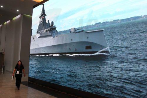 Μία γυναίκα περνά μπροστά από μία γιγαντοοθόνη που προβάλει τη φρεγάτα Belharra στα εγκαίνια της διεθνούς έκθεσης άμυνας και ασφάλειας DEFEA 2025– Defence Exhibition Athens, η οποία πραγματοποιείται από τις 6 έως και τις 8 Μαΐου στο Athens Metropolitan Expo, Σπάτα, Τρίτη 6 Μαΐου 2025. ΑΠΕ-ΜΠΕ/ΑΠΕ-ΜΠΕ/Αλέξανδρος Μπελτές
