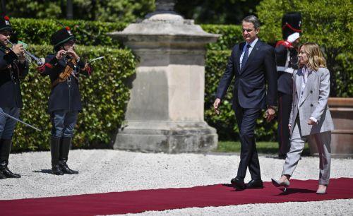 epa12093600 Italian Prime Minister Giorgia Meloni (R) and Greek Prime Minister Kyriakos Mitsotakis (2-R) inspect the guard of honor at Villa Pamphili ahead of the Italy-Greece Intergovernmental Summit in Rome, Italy, 12 May 2025.  EPA/RICCARDO ANTIMIANI