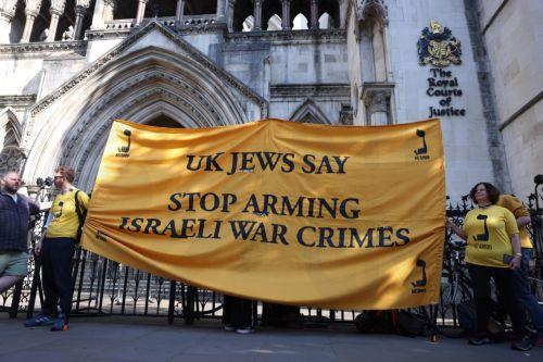 epa12095681 Protesters carry a banner as they demonstrate against selling arms to Israel at the Royal Courts of Justice in London, Britain, 13 May 2025. A four-day judicial review brought by Palestinian rights group Al-Haq and the Global Legal Action Network (GLAN) starts in the High Court on 13 May, with human rights' groups and lawyers arguing that UK's...