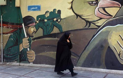 epa12121609 A veiled Iranian woman walks past a wall painting of Iranian Revolutionary Guard Corps (IRGC) soldiers in Tehran, Iran, 21 May 2025. Iran and US talks have paused as both sides made remarks against each other in recent days. According to the Iranian Foreign Ministry, Iranian Foreign Minister Abbas Araghchi said on 21 May 2025 that they are...