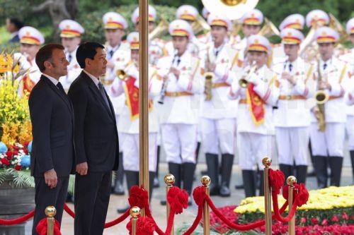 epa12136042 Vietnam's President Luong Cuong (2-L) and French President Emmanuel Macron (L) attend a welcome ceremony at the Presidential Palace in Hanoi, Vietnam, 26 May 2025.  EPA/Chalinee Thirasupa / POOL