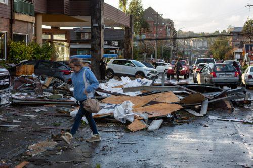epa12136054 A woman walks past the wreckage left behind by a tornado in Puerto Varas, Chile, 25 May 2025. More than fifteen thousand homes remain without electricity and other basic supplies in the tourist city of Puerto Varas, in southern Chile, after being hit by a tornado that destroyed more than a hundred houses and left a dozen injured.  EPA/FELIPE...