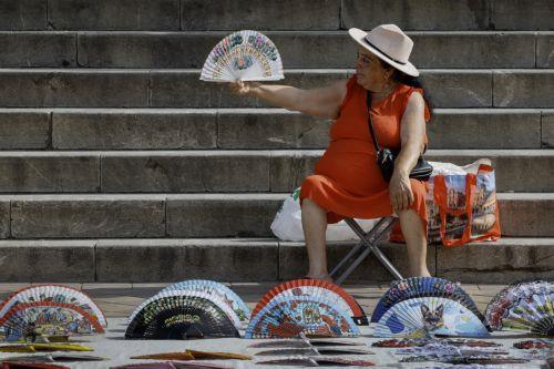 epa12144784 A vendor offers hand fans to tourists on a street amid an extreme heatwave in Seville, southern Spain, 30 May 2025. Temperatures are expected to reach 40 degrees Celsius in Seville on 30 and 31 May 2025, according to the Met Office.  EPA/JOSE MANUEL VIDAL