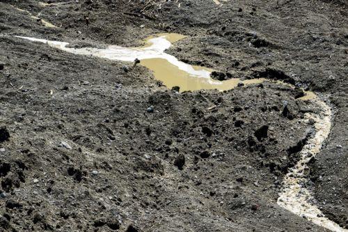 epa12144827 Water from the Lonza river flows over the mud and stone, after the formation of a lake on the last houses of the village of Blatten, Switzerland, 30 May 2025. A large part of the Blatten village, located in the Loetschental Valley in the canton of Valais, was buried under masses of ice, mud, and rock on 28 May after several million cubic meters...