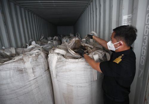 epa12167603 A Thai Customs official examines confiscated hazardous Electric Arc Furnace (EAF) Dust or 'red dust' hidden inside shipping containers at the Customs X-Ray and Technology Center, Bangkok Port Customs Office in Bangkok, Thailand, 10 June 2025. Thai authorities seized 736 tons of Electric Arc Furnace (EAF) dust, or 'red dust', concealed in 36...