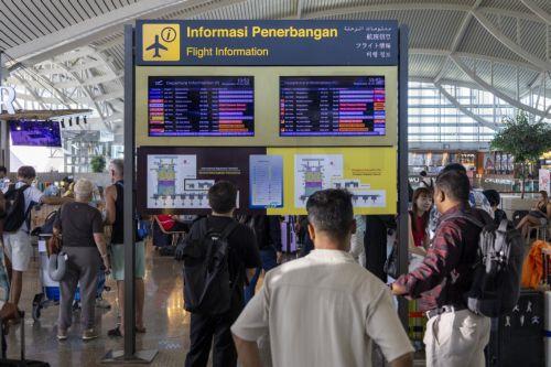 epa12182596 People view flight information at Ngurah Rai International Airport in Bali, Indonesia, 18 June 2025. Numerous flights to and from Bali were canceled following the eruption of Mount Lewotobi Laki-Laki in East Nusa Tenggara on 17 June 2025. The volcano sent a massive ash plume soaring 10 km high.  EPA/MADE NAGI