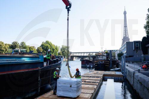 epaselect epa12185057 Workers operate on the construction site of the future Grenelle swimming site on the Seine River bank, in the Port de Grenelle, in Paris, France, 19 June 2025. Parisians will be able to swim in the Seine river from 05 July until 31 August 2025, with three swimming sites preparing to open for the public as part of Paris Plages 2025. ...