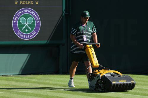 epa12205802 Groundskeepers tend to the courts during the Wimbledon Championships in London, Britain, 30 June 2025. The Wimbledon Championships 2025 will be played from 30 June to 13 July 2025.  EPA/NEIL HALL