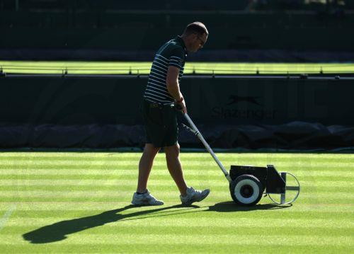 epa12205806 Groundskeepers tend to the courts during the Wimbledon Championships in London, Britain, 30 June 2025. The Wimbledon Championships 2025 will be played from 30 June to 13 July 2025.  EPA/NEIL HALL