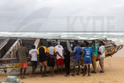 epa12209349 Local residents take a close look at a pirogue used to carry migrants stranded on Malibu beach, Guediawaye, near Dakar, Senegal, 01 July 2025. The pirogue left The Gambia, bound for Europe, on 25 June 2025 carrying more than 200 migrants according to the police, including mothers and children. An unspecified numbers of would be migrants ran away...