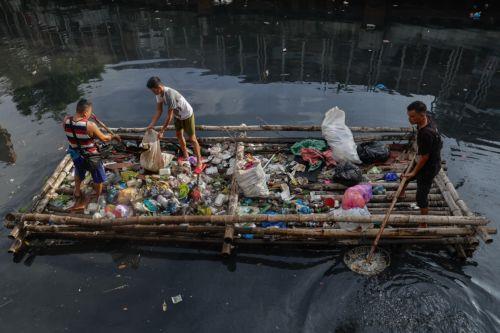 epa12216969 Villagers on a bamboo raft collect trash along a creek in Manila, Philippines 05 July 2025. The mayor of Manila ordered intensified waste collection and cleanup operations of waterways, canals and populated areas beginning 05 July, after declaring a health emergency on just his first week as newly-elected city head.  EPA/ROLEX DELA PENA