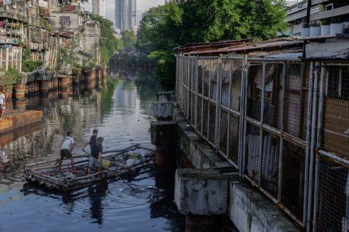 epa12216989 epaselect epa12216973 Villagers on a bamboo raft collect trash along a creek in Manila, Philippines 05 July 2025. The mayor of Manila ordered intensified waste collection and cleanup operations of waterways, canals and populated areas beginning 05 July, after declaring a health emergency on just his first week as newly-elected city head. ...
