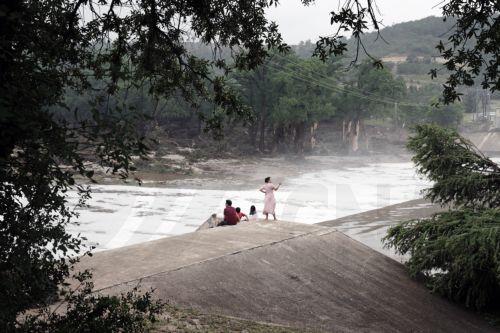 epaselect epa12218643 People watch the Guadalupe River flow over a dam in Kerrville, Texas, USA 05 July 2025. Twenty seven people are confirmed dead and dozens missing after floodwaters swept through a summer camp and nearby homes early 04 July. Search and Rescue teams continue working around the clock following flash flooding on the Guadalupe River in Kerr...