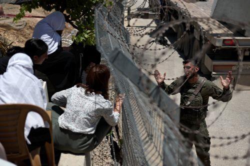 epaselect epa12242716 Druze people speak to an Israeli soldier through the border fence at the ceasefire line between Golan Heights and Syria, near the Druze village of Majdal Shams, in the Golan Heights, 17 July 2025. Syrian government officials and Druze minority leaders reached a new ceasefire agreement on 16 July, after the previous one collapsed,...