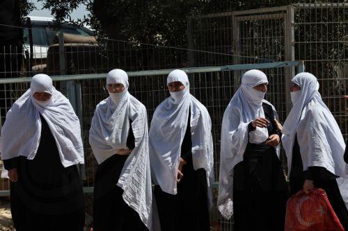 epa12242975 Druze people wait next to the gate at the ceasefire line between the Golan Heights and Syria, near the Druze village of Majdal Shams, in the Golan Heights, 17 July 2025. Syrian government officials and Druze minority leaders reached a new ceasefire agreement on 16 July, following days of clashes between Bedouin tribes, Druze militants and...