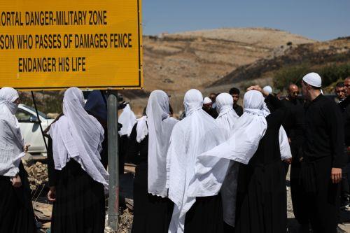 epa12242979 Druze people wait next to the gate at the ceasefire line between the Golan Heights and Syria, near the Druze village of Majdal Shams, in the Golan Heights, 17 July 2025. Syrian government officials and Druze minority leaders reached a new ceasefire agreement on 16 July, following days of clashes between Bedouin tribes, Druze militants and...