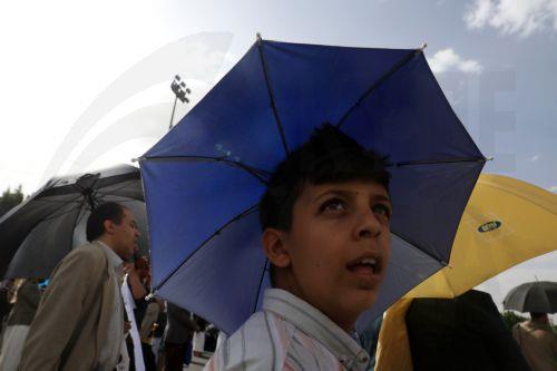 epa12245990 People hold umbrellas to shield themselves from the sun amid hot weather in Sana'a, Yemen, 18 July 2025. Yemen's national meteorological service warned about hot weather with temperatures ranging between 32 and 43 degrees Celsius across most parts of the Arab country.  EPA/YAHYA ARHAB