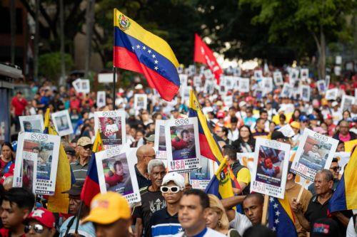 epa12246307 People hold signs during a demonstration in support of the separated children of deported Venezuelan migrants in Caracas, Venezuela, 18 July 2025.  EPA/Ronald Pena R