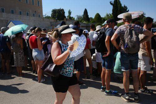 epa12249126 Tourists wear hats and  use fans and umbrellas as they stroll in the city center during a heatwave, in Athens, Greece, 20 July 2025. An intense heatwave with temperatures exceeding 44 degrees Celsius in some locations is expected in Greece and parts of the Balkans from Monday 21 July, according to a forecast issued by the National Observatory of...