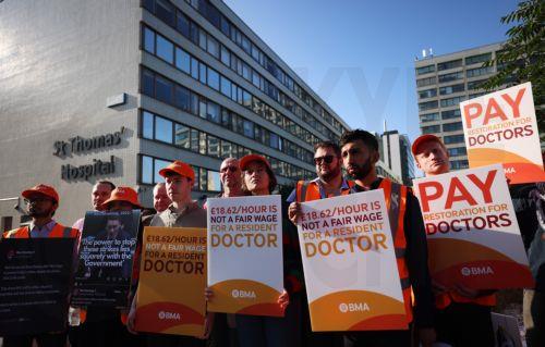 epa12260606 Resident doctors on strike hold placards outside St. Thomas’s hospital in London, Britain, 25 July 2025. Resident doctors have begun a five-day strike across England and Wales over pay and work conditions.  EPA/ANDY RAIN