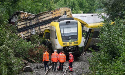 epa12267654 Emergency workers of German Railroad company (DB) stand on the railway track in front a derailed passenger train near Riedlingen, Germany, 28 July 2025. According to the police and fire department, three people died and around 50 were injured.  EPA/RONALD WITTEK