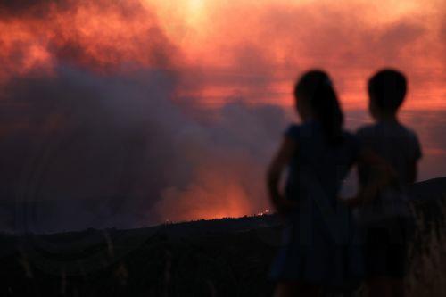 epa12271461 Children watch the fire in Arouca, Portugal, 29 July 2025. The fire that has been raging for more than 24 hours in Arouca, in the district of Aveiro, has three active fronts and has already reached the parish of Santa Eulalia, the local authority said.  EPA/ESTELA SILVA