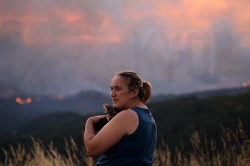 epa12271464 A local woman watches the fire in Arouca, Portugal, 29 July 2025. The fire that has been raging for more than 24 hours in Arouca, in the district of Aveiro, has three active fronts and has already reached the parish of Santa Eulalia, the local authority said.  EPA/ESTELA SILVA