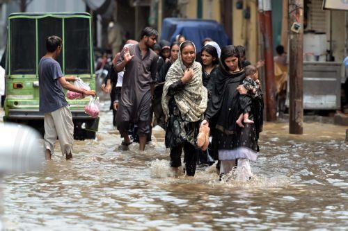 epa12282412 People wade through through heavy monsoon rains in Lahore, Pakistan, 03 August 2025. The Pakistan Meteorological Department warns that the currently weak monsoon currents are set to intensify 04 to 07 of August, bringing further rain and storms to Lahore and central Punjab.  EPA/RAHAT DAR 92299