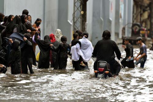 epaselect epa12282407 People wade through through heavy monsoon rains in Lahore, Pakistan, 03 August 2025. The Pakistan Meteorological Department warns that the currently weak monsoon currents are set to intensify 04 to 07 of August, bringing further rain and storms to Lahore and central Punjab.  EPA/RAHAT DAR 92299