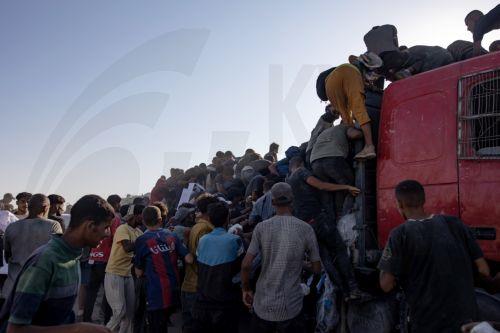 epa12283315 Internally displaced Palestinians climb aid trucks to get food near a food distribution point in the Morag corridor, south of Khan Younis, in the southern Gaza Strip, 04 August 2025.  EPA/HAITHAM IMAD