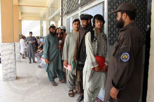 epa12288353 Afghans wait in line to register with authorities for a labor program to work in Qatar, in Kandahar, Afghanistan, 07 August 2025. More than 15,000 Afghans have registered for a labor program to work in Qatar, far exceeding the 3,100-worker quota agreed upon between the Taliban government and Doha. The mass turnout at registration centers in...