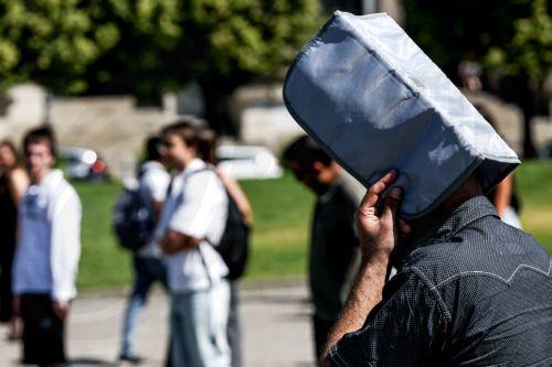 epa12295212 A man covers his head from the sun during a hot day in central Berlin, Germany, 12 August 2025.  EPA/FILIP SINGER