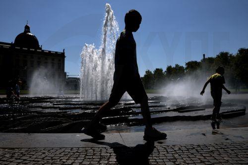 epa12295214 A boy walks next to a public fountain during a hot day in central Berlin, Germany, 12 August 2025.  EPA/FILIP SINGER