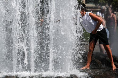 epa12295217 A boy cools off at a public fountain during a hot day in central Berlin, Germany, 12 August 2025.  EPA/FILIP SINGER