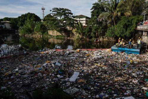 epa12311483 Workers from city environment and sanitation services collect trash and debris from a creek during a clean-up operation at the boundary of San Juan and Quezon City, Metro Manila, Philippines, 20 August 2025. Almost two consecutive weeks of typhoon and heavy monsoon rains in the month of July triggered massive flooding in Metro Manila and several...