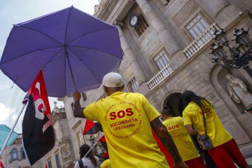 epa12316543 Lifeguards protest for better working conditions outside the City Hall in Barcelona, northeastern Spain, 22 August 2025. Barcelona's lifeguards are on a strike since 01 August 2025.  EPA/Quique Garcia