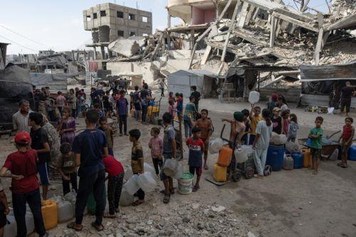 epa12319447 Displaced Palestinians wait to fill containers with drinking water amid the destruction in the Khan Younis camp, southern Gaza Strip, 24 August 2025. According to the UN around 90 per cent of the population or 1.9 million people in Gaza have been displaced since the start of the conflict.  EPA/HAITHAM IMAD