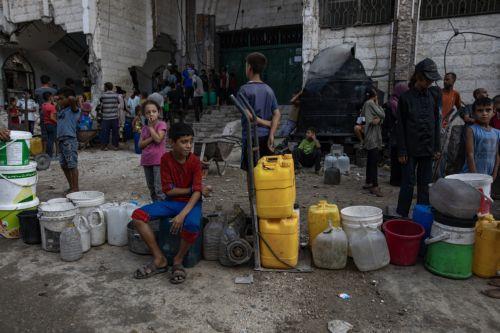 epa12319451 Displaced Palestinians wait to fill containers with drinking water amid the destruction in the Khan Younis camp, southern Gaza Strip, 24 August 2025. According to the UN around 90 per cent of the population or 1.9 million people in Gaza have been displaced since the start of the conflict.  EPA/HAITHAM IMAD