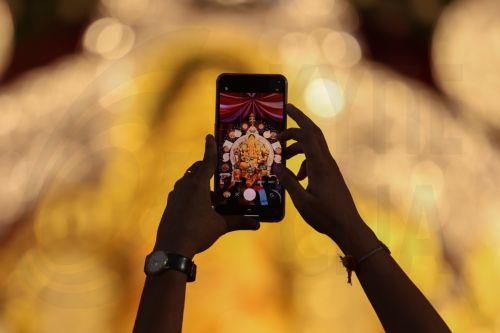 epa12322132 A devotee takes photos of an idol of Lord Ganesh, adorned with 69+ kilogram of gold ornaments and 336 kilogram of silver, on his mobile phone, at Gowd Saraswat Brahman (G.S.B.) Seva Mandal non-profit organization, during the first look event ahead of Ganesh festival in Mumbai, India, 25 August 2025. The Ganesh Chaturthi festival is a ten-day...