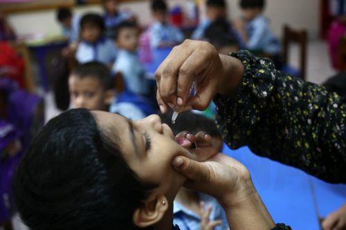 epa12342237 A health worker marks the thumb of a child at a school during a door-to-door vaccination campaign, in Karachi, Pakistan, 01 September 2025. A week-long anti-polio campaign was set to begin on 01 September in 99 high-risk districts across Pakistan, excluding nine flood-affected districts in eastern Punjab, health officials said. The drive aims to...