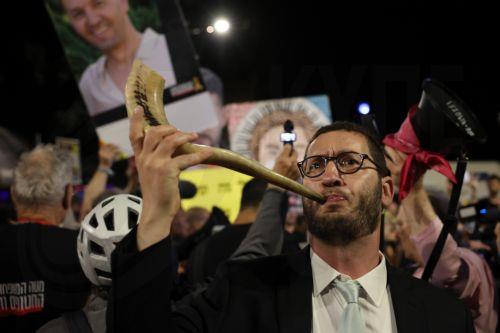 epa12393893 A protester blows a shofar musical horn as families and supporters of Israeli hostages held by Hamas in the Gaza Strip take part in a protest calling on the Israeli government to stop the war in Gaza and for the immediate release of the hostages, outside the Israeli Prime Minister's residence in Jerusalem, 20 September 2025.  EPA/ABIR SULTAN
