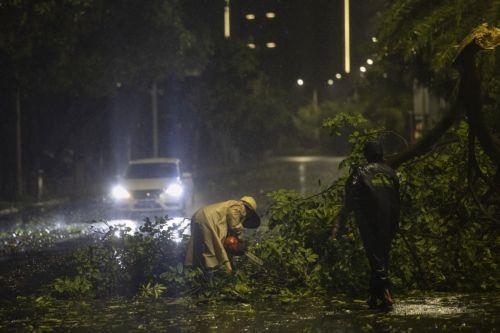 epa12402154 Workers clear a fallen tree branch from a road amidst the passage of Typhoon Ragasa in Maoming, Guangdong province, China, 24 September 2025. Typhoon Ragasa, the year's most powerful tropical cyclone, made landfall on the southern coast of China in Guangdong province, leading to the relocation of over 2 million people, according to Chinese state...