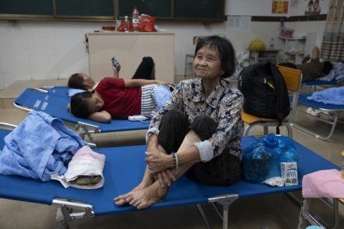 epa12402157 People rest at a temporary resettlement site set up inside Bomei Primary School in Bohe Town, amidst the passage of Typhoon Ragasa in Maoming, Guangdong province, China, 24 September 2025. Typhoon Ragasa, the year's most powerful tropical cyclone, made landfall on the southern coast of China in Guangdong province, leading to the relocation of...