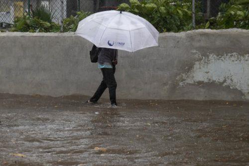 epa12471600 A person walks through a flooded street in Santo Domingo, Dominican Republic, 21 October 2025. The Dominican Republic activated emergency plans in response to heavy rainfall forecast from Tropical Storm Melissa, which formed in the Caribbean Sea and triggered warnings for the Dominican Republic, Haiti, and Jamaica.  EPA/ORLANDO BARRIA